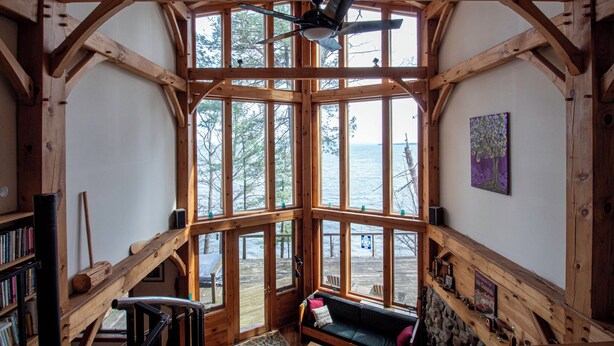 A cabin with large windows, a ceiling fan, and a view of the water. - Architects Dream Home Overlooking Picturesque Lake Champlain (Keeseville)