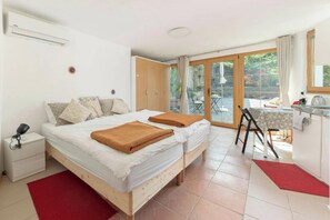 Quarto com uma cama, uma escrivaninha e vista para o exterior.