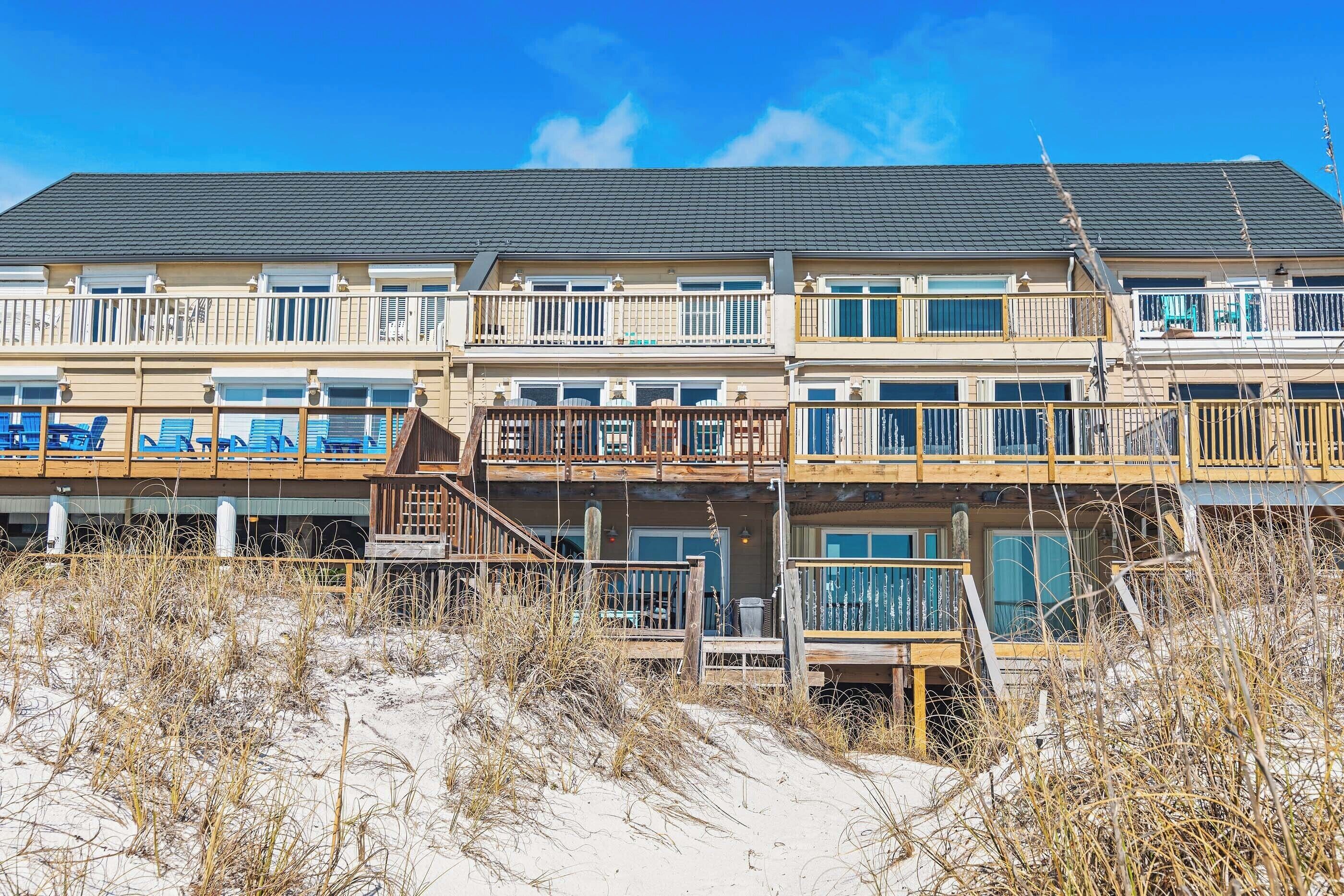 A multi-story hotel with balconies and outdoor seating areas.