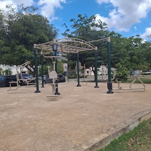 Work out in a serene park setting with a variety of fitness equipment.