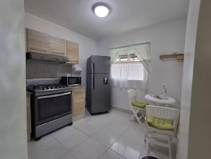 Prepare meals in the kitchen with a stove, microwave, and refrigerator. Enjoy dining near a window with a view of the outdoors.