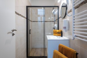 Superior studio | Badkamer | Een douche, een haardroger, handdoeken, zeep
