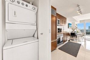 A modern kitchen with a built-in oven, a microwave, and a refrigerator.