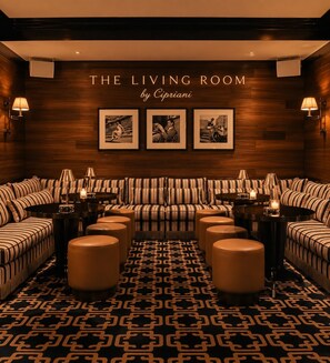 A living room with striped sofas, round tables, and wall-mounted lamps. - STUDIO APARTMENT DOWNTOWN | ICON-BRICKELL (Miami)