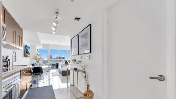A modern kitchen with a dining area, a large window, and a view of the city.