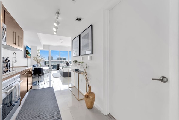 A modern kitchen with a dining area, a large window, and a view of the city.