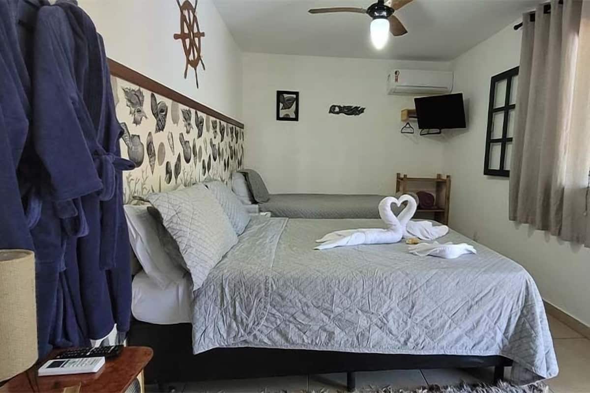 Une chambre à coucher comprenant un lit, un bureau, une chaise, un ventilateur de plafond et un mur agrémenté d’éléments décoratifs.
