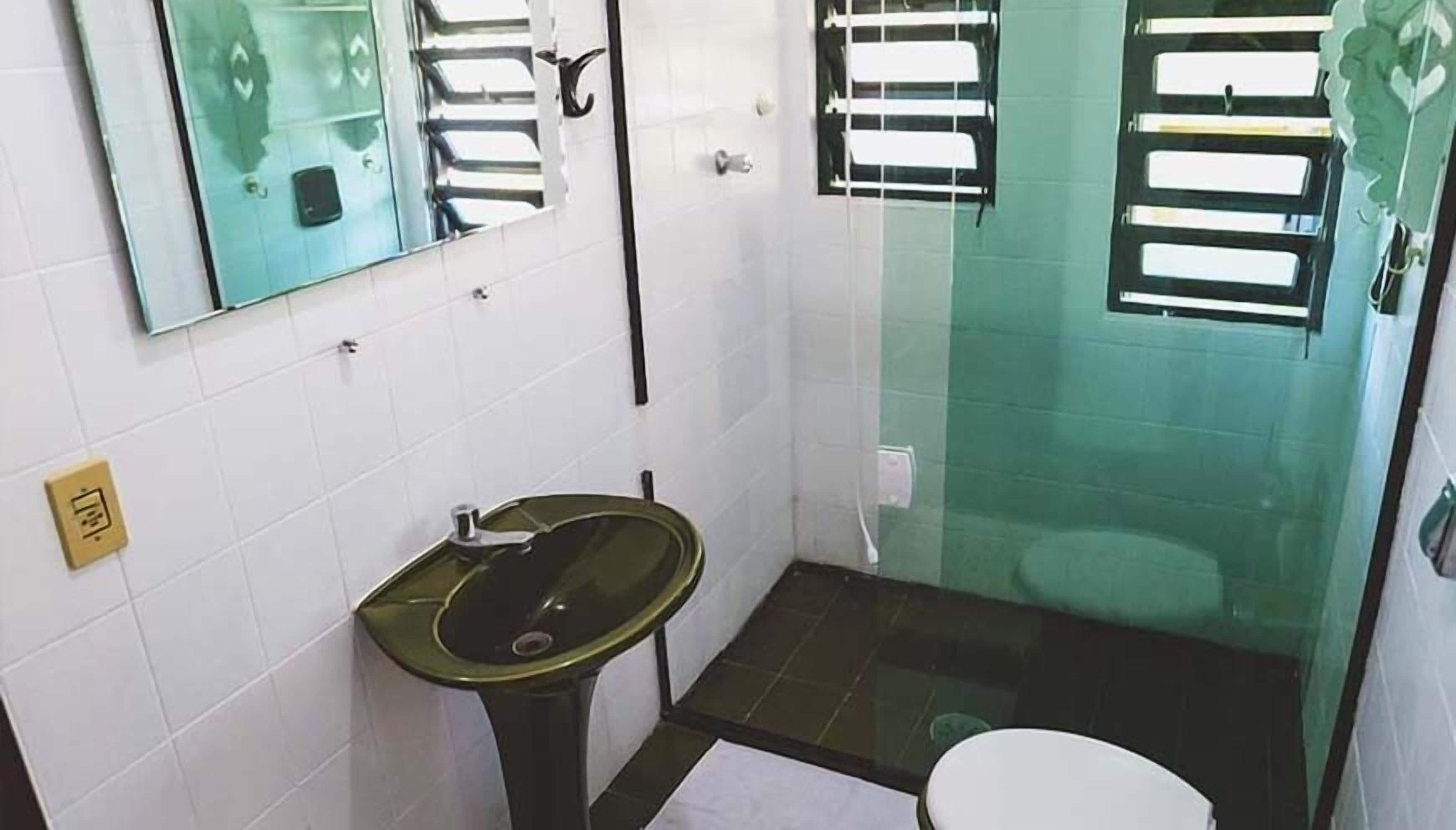 A small bathroom with a sink, toilet, and a mirror.