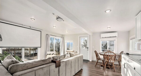 A modern kitchen with a dining area, large windows, and a built-in bench with cushions. - River’s Edge Retreat Cozy Waterfront Getaway - Waterfront for your city stay! (Grand Rapids)