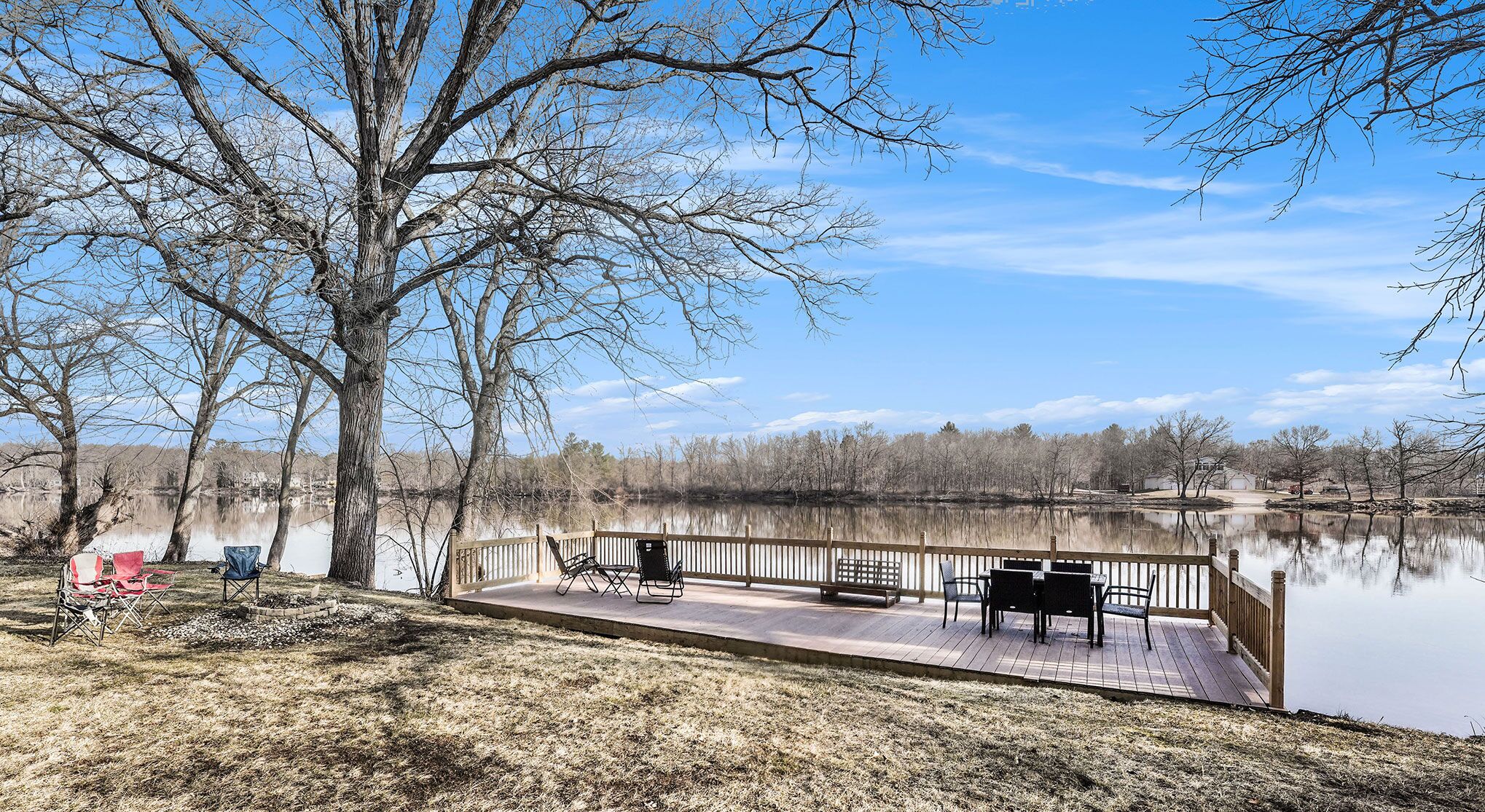 A lakeside deck with outdoor seating and a view of the lake.