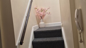 Un escalier sur lequel est accrochée une pancarte indiquant «NOTRE endroit préféré» et, au sommet, un vase rempli de fleurs roses.