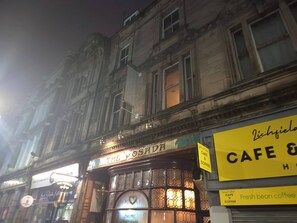 A street view at night with a building featuring a cafe sign. - Our Apartment is a Home Away From Home Choice, Tastefully Furnished for Comfort (Wolverhampton)