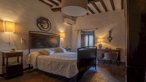 Ein Schlafzimmer mit einem großen Bett, einem Schreibtisch, einem Stuhl und einem Fenster.