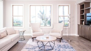 Amplia sala de estar con sofá, dos sillones, una mesa de centro y un mueble para la televisión.