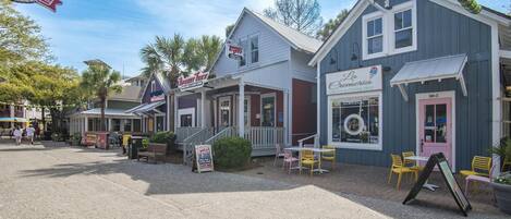 A street with buildings, including a food and oyster house, a pizza place, and a cafe.