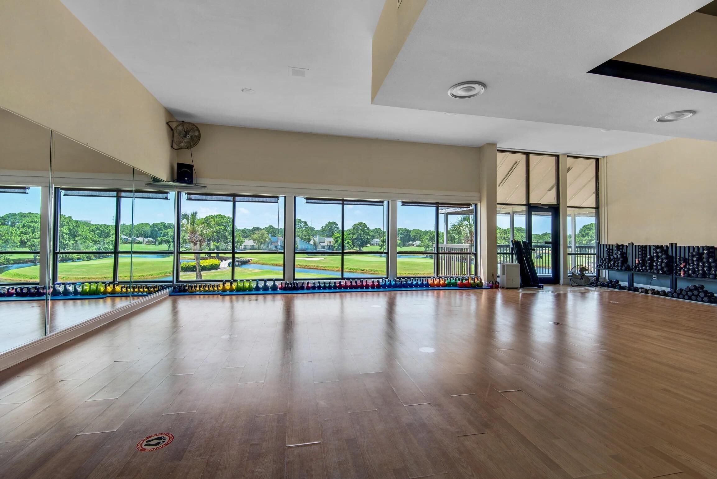 Amplia habitación con grandes ventanales y vista a un campo de golf.