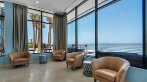 Un área de descanso con sillas de mimbre y vista a la playa.