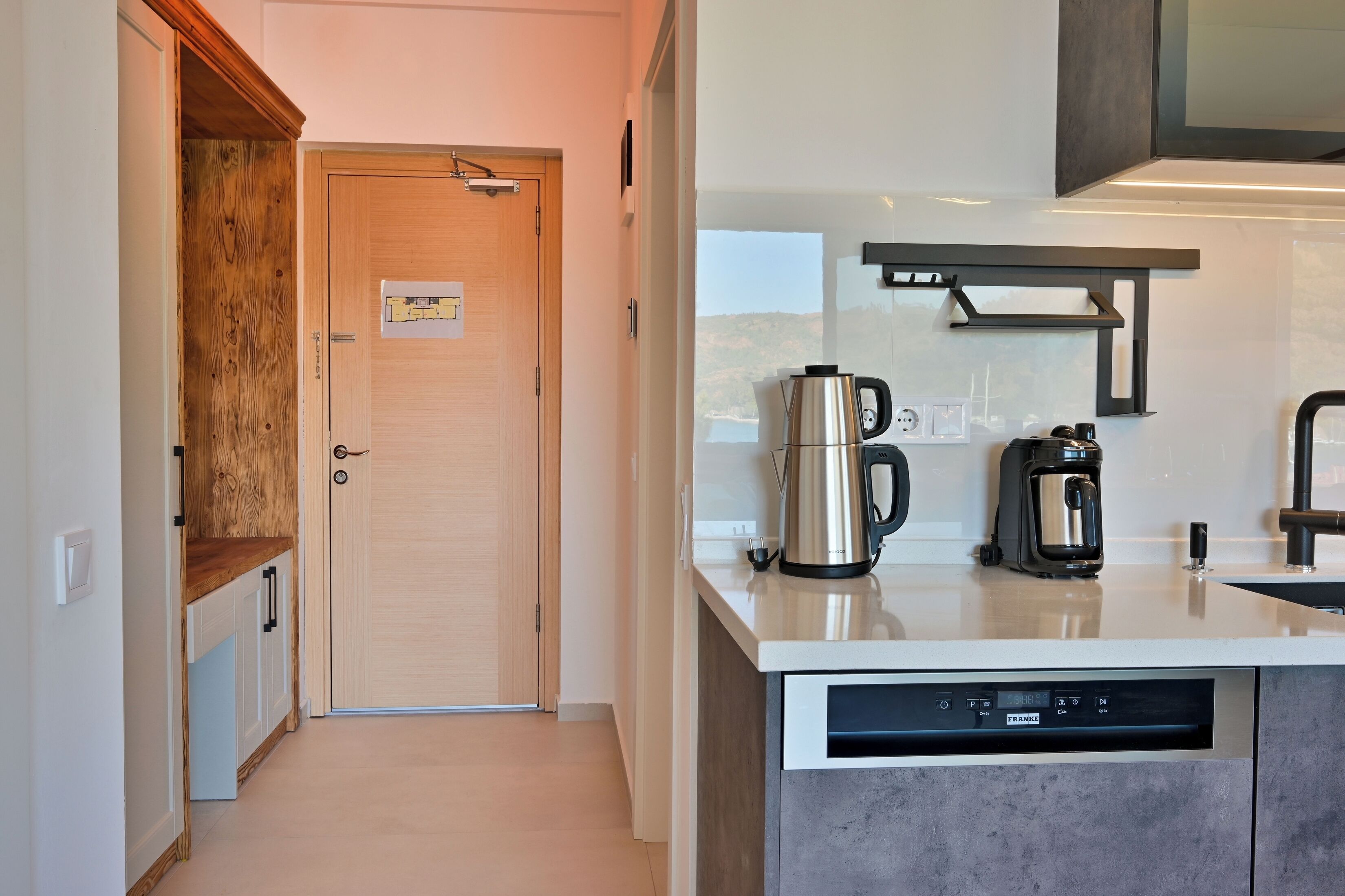 Una cocina moderna con puerta de madera, electrodomésticos de acero inoxidable y lavavajillas.