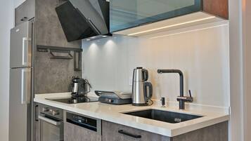 Una cocina moderna con horno empotrado, cafetera y pileta.