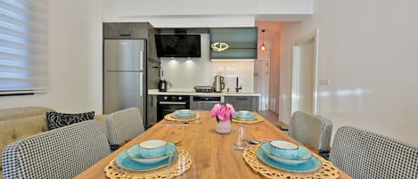 A modern kitchen with a built-in oven, microwave, and a large refrigerator.
