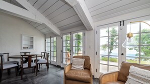 A spacious room with a dining area, large windows, and a view of the outdoors. - (3 Nt Min) Lakefront Stunner Has It All! (Stevensville)