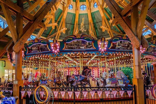 Un carrousel agrémenté de décorations raffinées et doté d’une structure de plafond en bois.