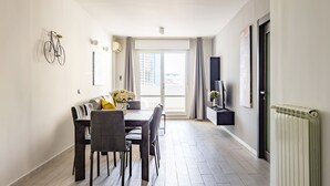 A modern dining area with a table and chairs, a bicycle mounted on the wall, and a view through a glass door. - Casa Kenzo With Parking by Napoliapartments (Naples)