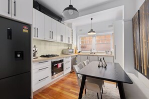 Enjoy meals in this kitchen with a dining table and chairs, featuring a window with a view.