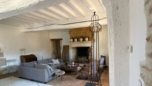 A living room with a fireplace, a sofa, a coffee table, and a patterned rug.