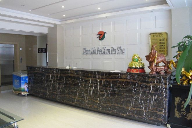 A reception desk with a marble top, a logo above it, and a plaque to the right.
