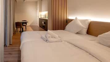 A hotel room with a bed, a desk, and a kitchenette.