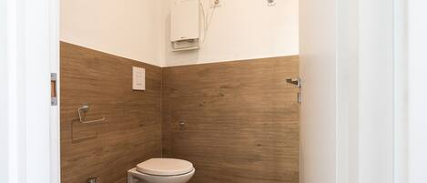 A small bathroom with a toilet, bidet, and sink.