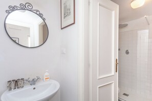 Een douche, een bidet, handdoeken, toiletpapier