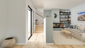 A modern living room with a sofa, a coffee table, and a bookshelf.
