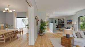 A modern living space with a wooden dining table, a sofa, and a bookshelf.
