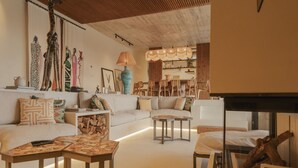 Un salon moderne avec un canapé, une table basse et une cheminée.