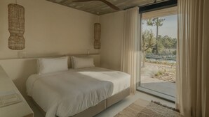 Une chambre à coucher avec un lit, un ventilateur de plafond et une vue sur l’extérieur.
