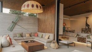 Un salon moderne avec un canapé d’angle, un foyer et un grand plafond en bois.
