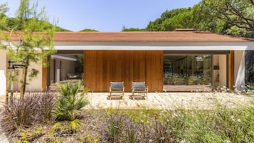 Relax in a serene outdoor space surrounded by lush greenery and comfortable seating.