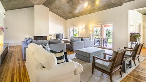 A spacious living area with a modern design, featuring a large sofa, a coffee table, and a television. - Grandola Mountain Paradise by Cadenzalux (Grandola)