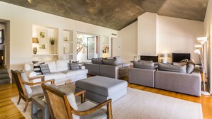 A modern living room with a grey sofa set, wooden chairs, and a flat-screen TV. - Grandola Mountain Paradise by Cadenzalux (Grandola)
