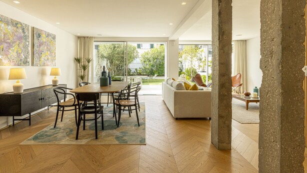 A modern living room with a dining area, large windows, and a view of greenery outside. - Contemporary Restelo Pool Haven by Cadenzalux (Lisbon)