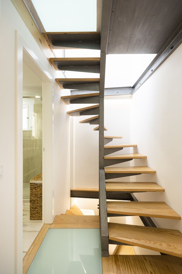A modern staircase with wooden steps and a glass bottom landing.