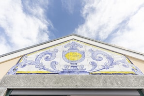 A building with a decorative tile mural featuring a central emblem and the inscription "CASA S. ANTONIO".