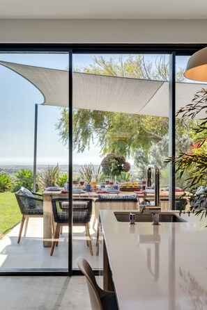 Un área de comedor exterior moderna con vistas al paisaje.
