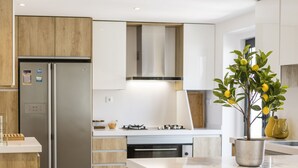 Una cocina moderna con una isla central, electrodomésticos de acero inoxidable y muebles de madera.
