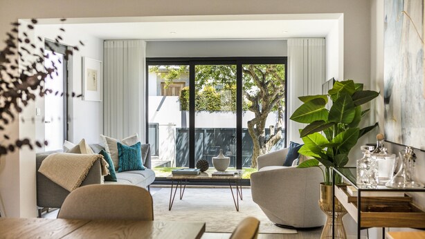 Una sala de estar moderna con un ventanal grande, un comedor y una mesa de centro.