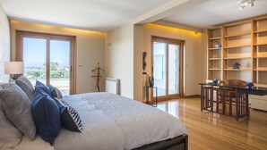 Un dormitorio con una cama grande, un escritorio y vistas al exterior.