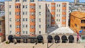 A multi-story hotel with a central courtyard, featuring a mix of architectural styles, including arched windows and a flat facade.