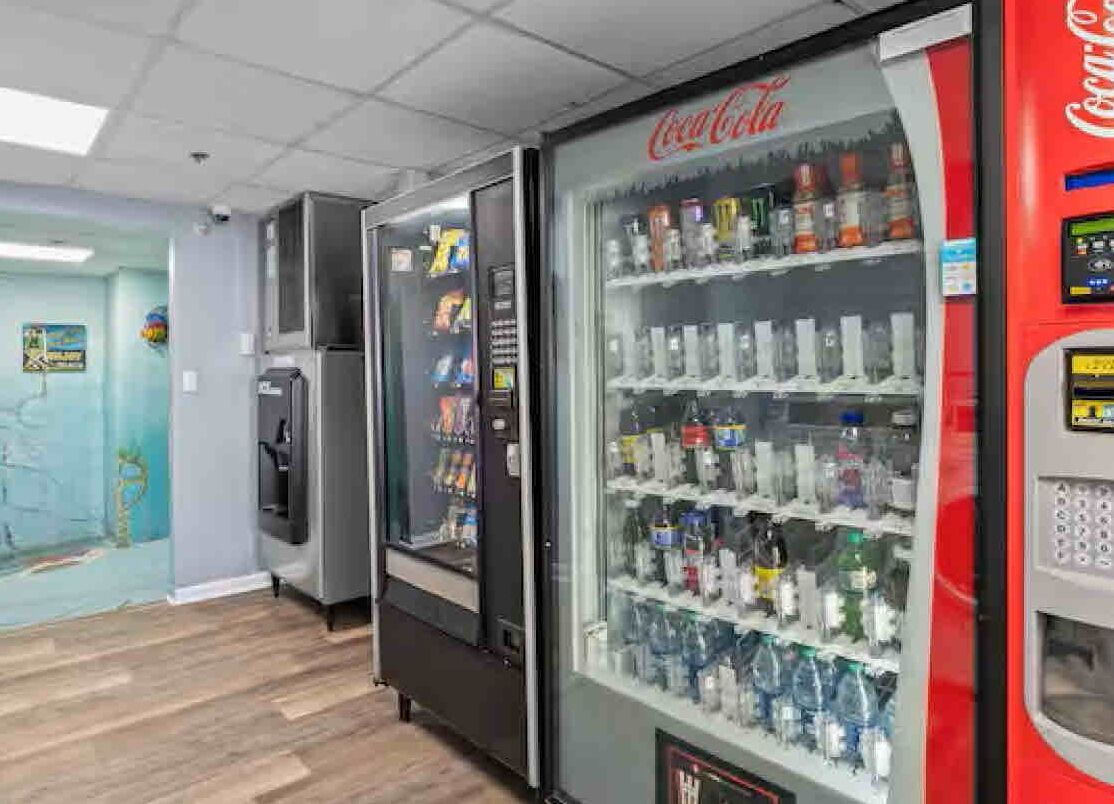 Un espace équipé de distributeurs automatiques proposant des produits Coca-Cola et d’autres boissons.